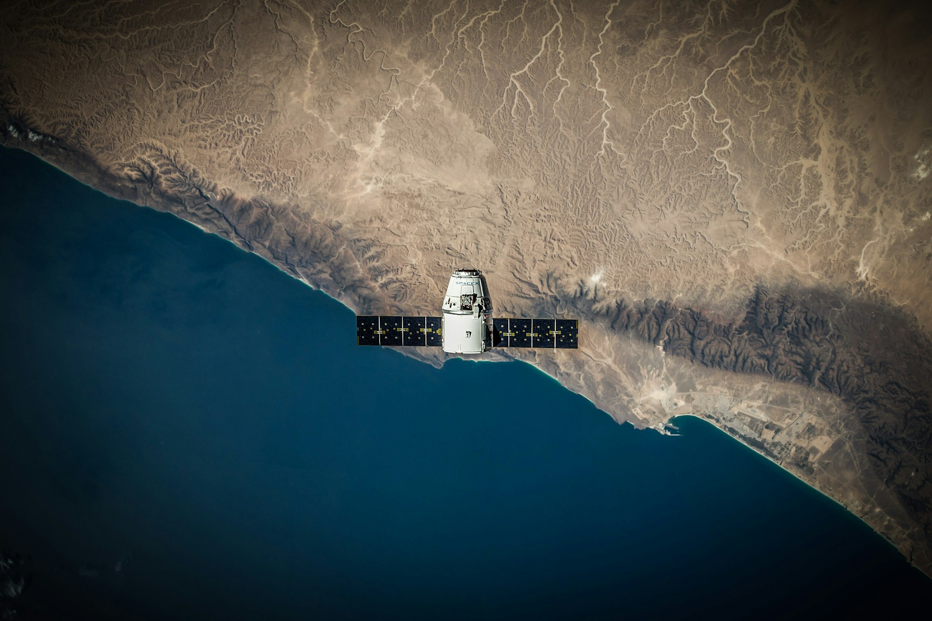 Spacecraft hovering above a coastline